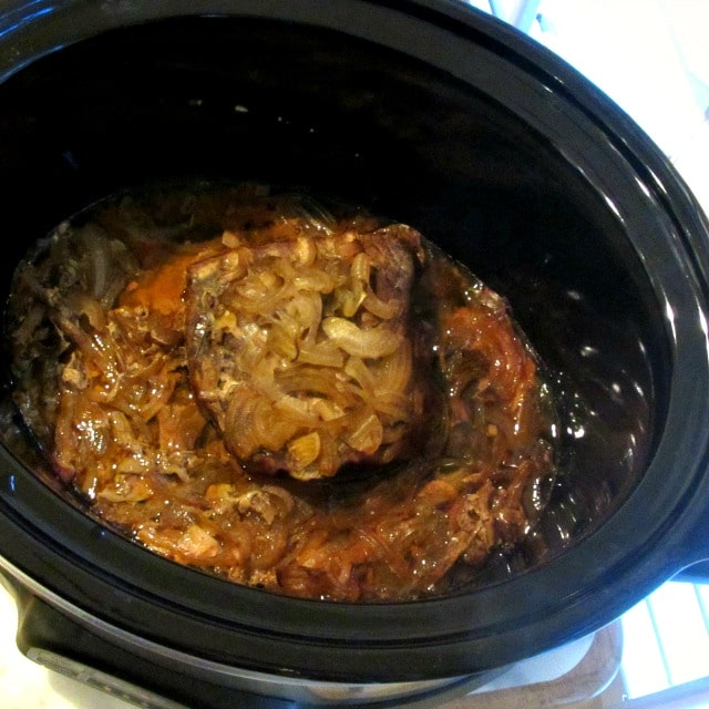 Cooked beef and onions in a slow cooker