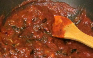 Stirring chopped cooked greens into pasta sauce - www.inhabitedkitchen.com