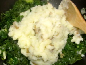 Adding potatoes to kale and onion for colcannon - www.inhabitedkitchen.com