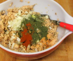 Adding seasoning to salmon to make patties - www.inhabitedkitchen.com