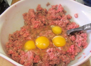 Mixing eggs and meat for meatloaf - www.inhabitedkitchen.com