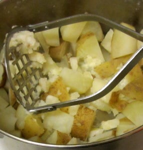 Mashing potatoes (coats and all) - www.inhabitedkitchen.com