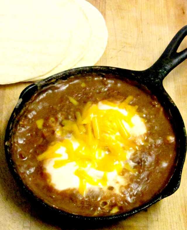 A quick, easy, and nutritious breakfast of beans and eggs, with perhaps a sprinkle of cheese, served over corn tortillas. www.inhabitedkitchen.com