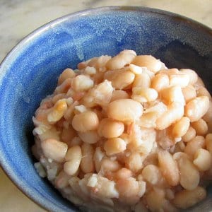 Blue bowl full of cooked Great Northern Beans