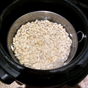 Beans and water in inside pot, set in pressure cooker, erady to cook.