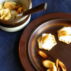Dish of roasted garlic, with a few cloves placed on canapes. 
