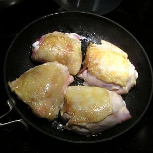 Chicken thighs cooking in pan