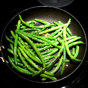 Add garlic to sauteed green beans while still in pan over heat