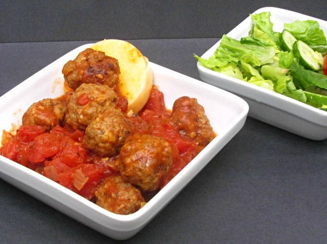 A dish with meatballs in tomato sauce, served over polenta. 