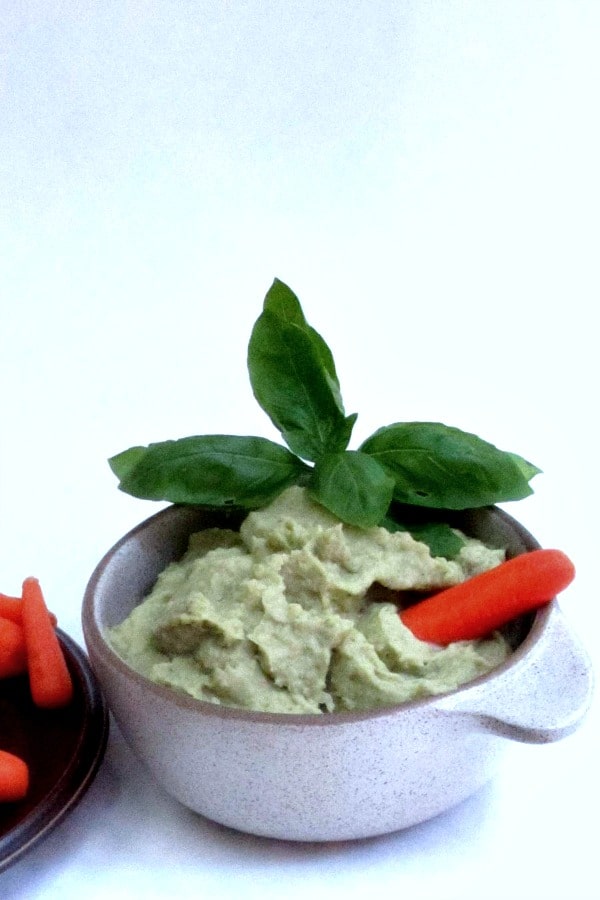 Bowl of Pesto Hummus served with baby carrots