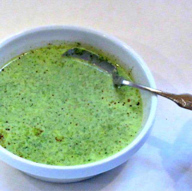 Bright green Cream of Spinach Soup in a white bowl.