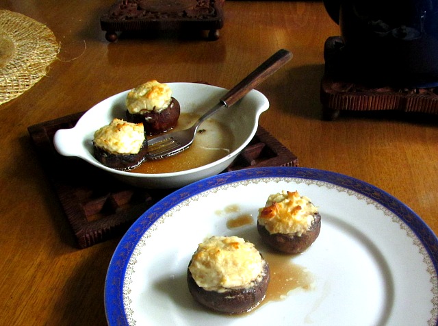 Cheese Stuffed Mushrooms served from a baking dish to a plate. 