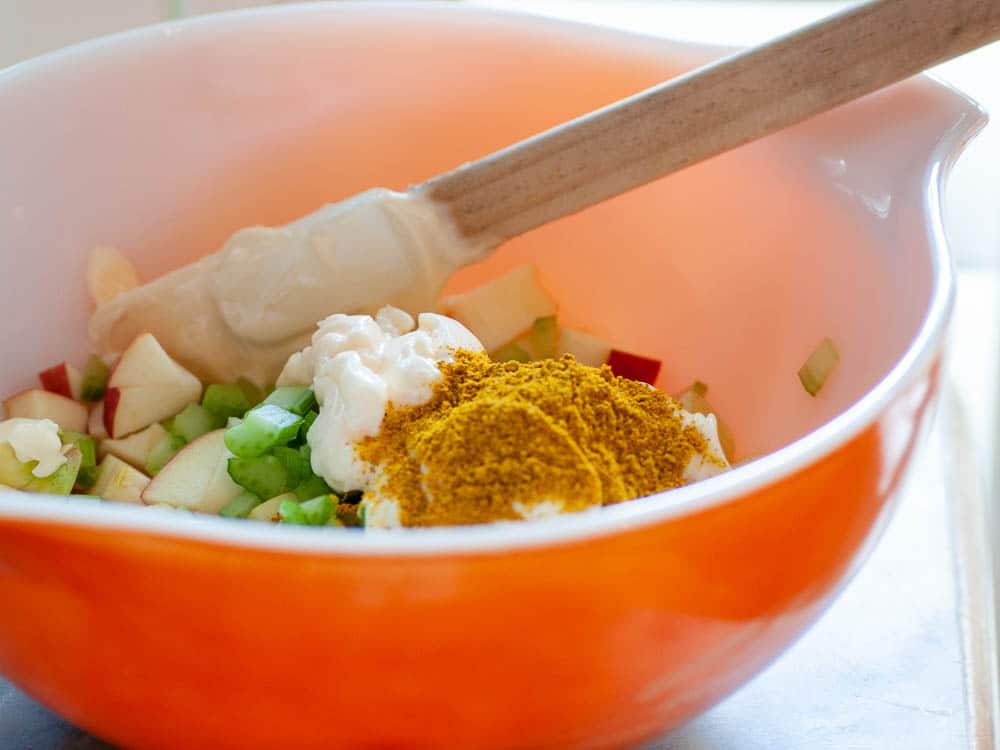 Ingredients for curried chicken salad in a bowl.